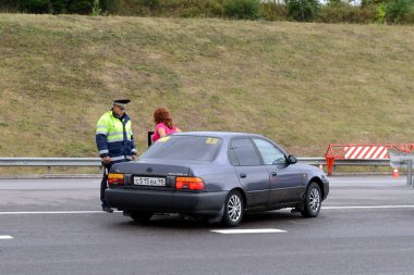  Trafik polisi bir kadın sürücü karayolu üzerinde konuşurken müfettişi.
