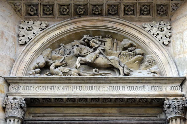 Relief föreställande St George Fighting draken på den södra portalen av basilikan med Yeresko Street Pragborgen. — Stockfoto