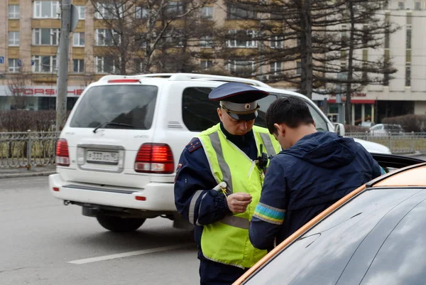 Инспектор дорожно-патрульной службы милиции проверяет документы таксиста в центре Москвы . — стоковое фото