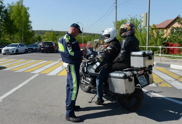 Inspektör av trafikpoliser kontrollerar dokumenten av motorcykeln. — Stockfoto