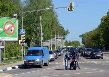  Subay polis motosikletçi bir şehir sokak üzerinde denetler.
