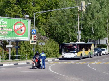  Subay polis motosikletçi bir şehir sokak üzerinde denetler.