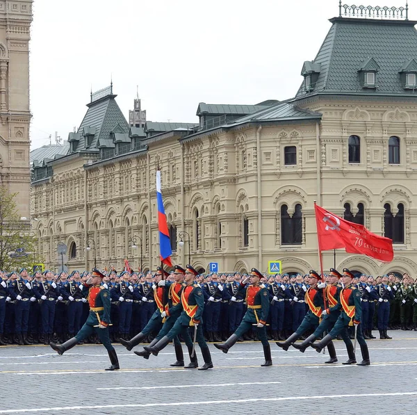 I soldati della guardia d'onore il comandante speciale del reggimento Preobrazhensky portano lo stendardo di Vittoria e la bandiera russa a una parata militare su quadrato rosso . — Foto Stock