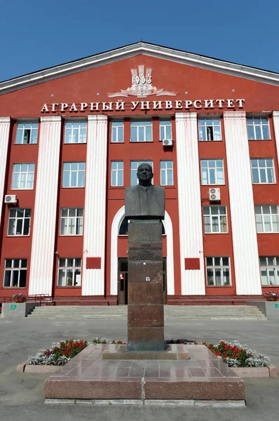 A monument to academician Michael lisavenko on the background of the Altai state agrarian University. — Stock Photo, Image