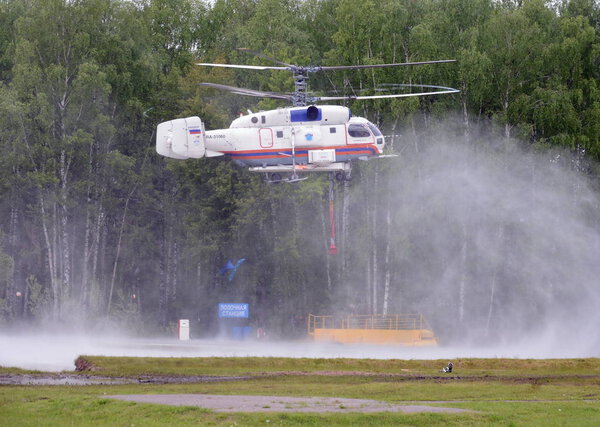  Fire-fighting helicopter -32  recovers water from the reservoir at the training ground of the Noginsk rescue center of the Ministry of Emergency Situations of Russia.