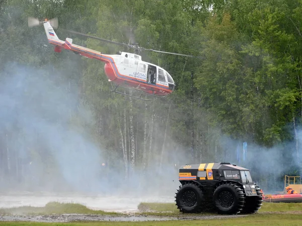 Helicopter BO-105 Centrospas and all-terrain vehicle "Sherp" on the range of the Noginsk rescue center EMERCOM of Russia. — Stock Image Helicopter BO-105 Centrospas and all-terrain vehicle "Sherp" on the range of the Noginsk rescue center EMERCOM of Russia. Stock Picture