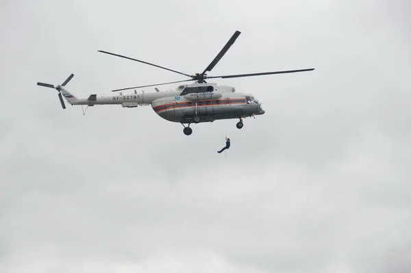 Le sauveteur descend de l'hélicoptère Mi-8 du ministère des Situations d'urgence de la Russie au terrain d'entraînement du centre de sauvetage de Noginsk . — Photo