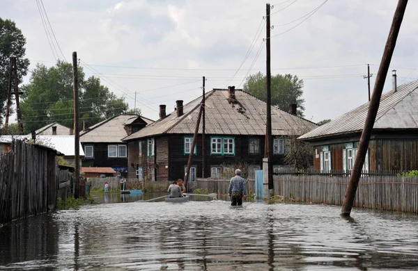 Locals move around the streets by boat. The Ob river, which came out of the banks, flooded the outskirts of the city. — Stock Photo, Image