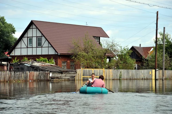 Locals move around the streets by boat. The Ob river, which came out of the banks, flooded the outskirts of the city. — Stock Photo, Image