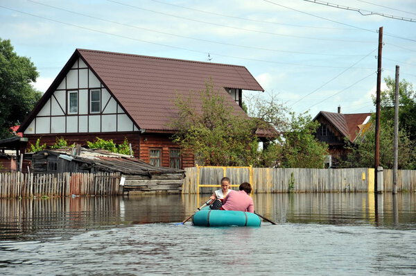Местные передвигаются по улицам на лодке. Река Обь, вышедшая из берегов, затопила окраины города.
.