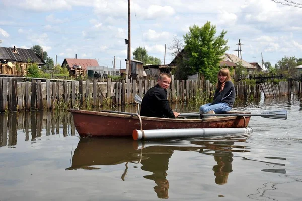 Locals move around the streets by boat. The Ob river, which came out of the banks, flooded the outskirts of the city. — Stock Photo, Image