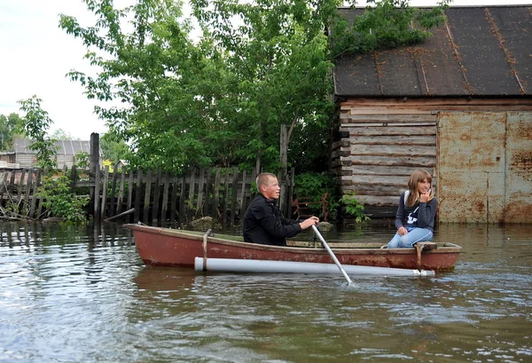 Locals move around the streets by boat. The Ob river, which came out of the banks, flooded the outskirts of the city. — Stock Photo, Image