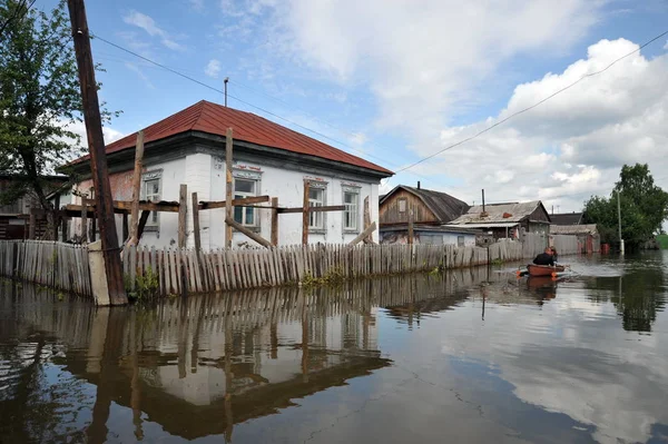 Locals move around the streets by boat. The Ob river, which came out of the banks, flooded the outskirts of the city. — Stock Photo, Image