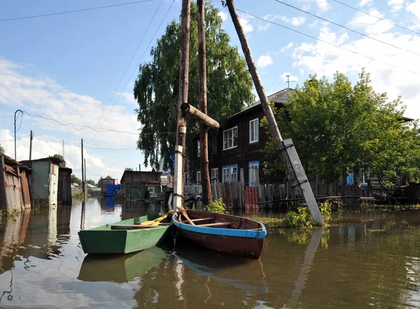 Flood. The river Ob, which emerged from the shores, flooded the outskirts of the city.Boats near the houses of residents — Stock Photo, Image