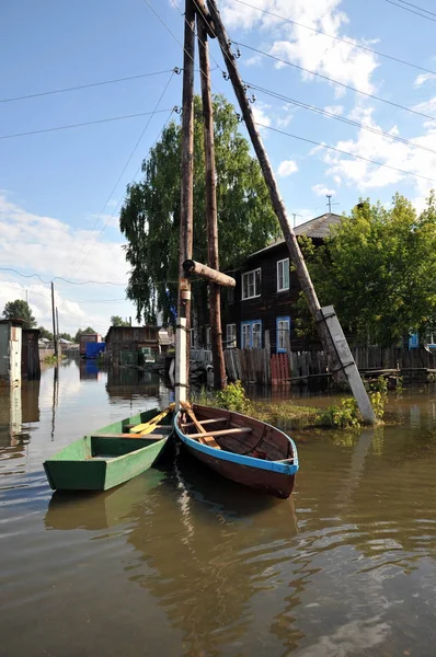 Flood. The river Ob, which emerged from the shores, flooded the outskirts of the city.Boats near the houses of residents — Stock Photo, Image