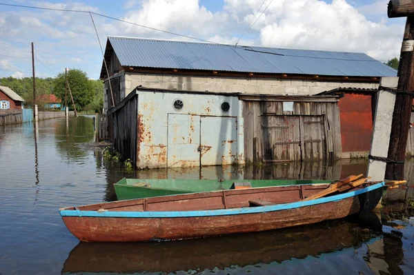 Flood. The river Ob, which emerged from the shores, flooded the outskirts of the city.Boats near the houses of residents — Stock Photo, Image