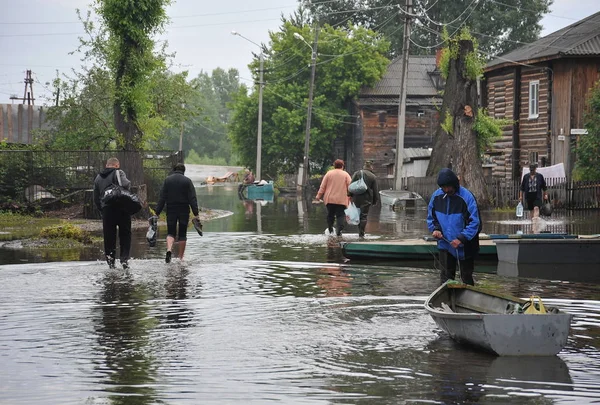 Local residents move around the streets during a flood. The Ob river, which came out of the banks, flooded the outskirts of the city. — Stock Photo, Image
