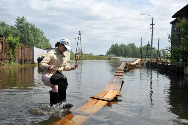 地元住民は洪水時に街を移動します。銀行から出てきた Ob 川氾濫都市の郊外. — ストック写真