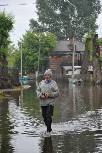 地元住民は洪水時に街を移動します。銀行から出てきた Ob 川氾濫都市の郊外. — ストック写真
