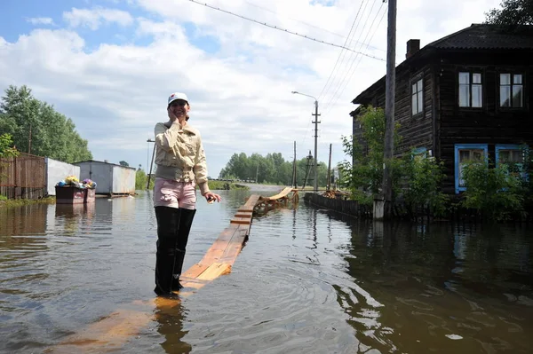 Los residentes locales se mueven por las calles durante una inundación. El río Ob, que salía de las orillas, inundaba las afueras de la ciudad . — Foto de Stock
