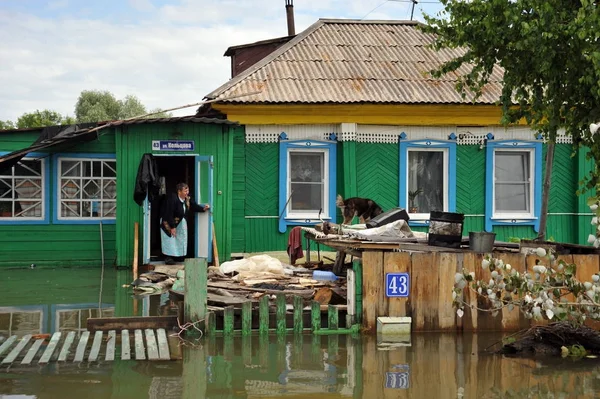 Una anciana desconocida en su casa durante una inundación. El río Ob, que salía de las orillas, inundaba las afueras de la ciudad . — Foto de Stock