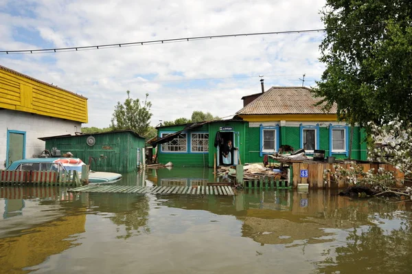 Una anciana desconocida en su casa durante una inundación. El río Ob, que salía de las orillas, inundaba las afueras de la ciudad . — Foto de Stock