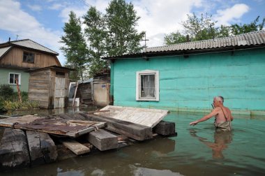 Bilinmeyen bir adamın evinin yakınındaki su dolu bir arsa üzerinde. Nehri kıyılarından ortaya çıkan, Ob, kentin eteklerinde sular altında..