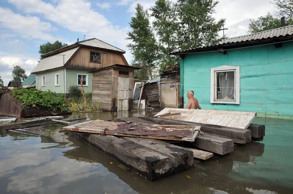 Un desconocido en una parcela inundada cerca de su casa. El río Ob, que surgió de las orillas, inundó las afueras de la ciudad . — Foto de Stock