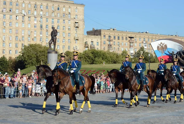 The cavalry honorary escort of the Presidential Regiment speaks against the background of the monument to the heroes of the First World War on Poklonnaya Hill. — Stock Photo, Image