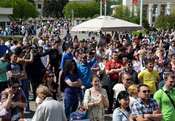  Люди во время празднования Дня Победы смотрят концерт на выставке экономических достижений
.