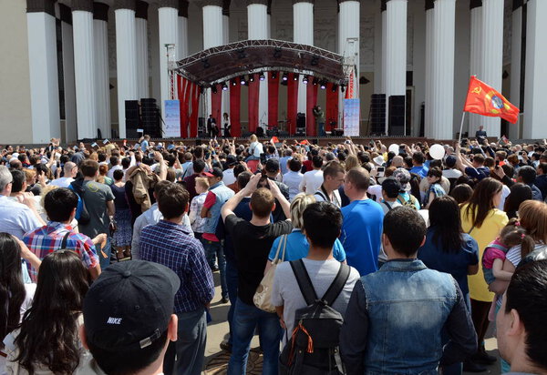  Люди во время празднования Дня Победы смотрят концерт на выставке экономических достижений
.