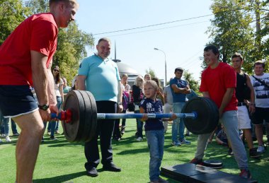  Bilinmeyen bir çocuk bir spor Festivali bir bar kaldırmaya çalışıyor.