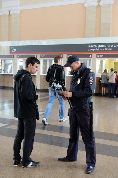 Поліцейський перевіряє документи від громадян на залізничному вокзалі Тульської станції. — стокове фото