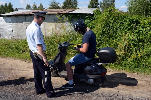 O inspetor da patrulha da polícia rodoviária verifica os documentos do motorista da moto . — Fotografia de Stock