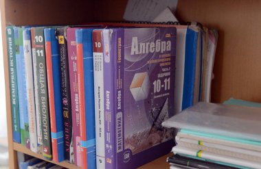  Bir lise öğrencisi rafta ders kitapları.