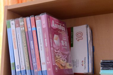  Bir lise öğrencisi rafta ders kitapları.