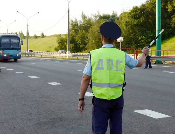 L'inspecteur de la patrouille de police routière arrête le bus interurbain pour vérifier . — Photo