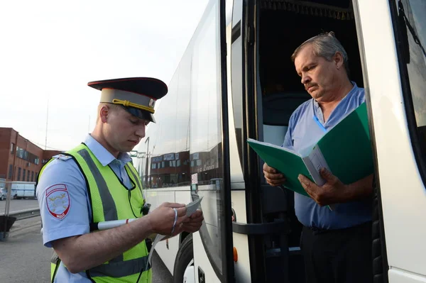 The inspector of the road police patrol checks documents from the driver of the intercity passenger bus. — Stock Photo, Image