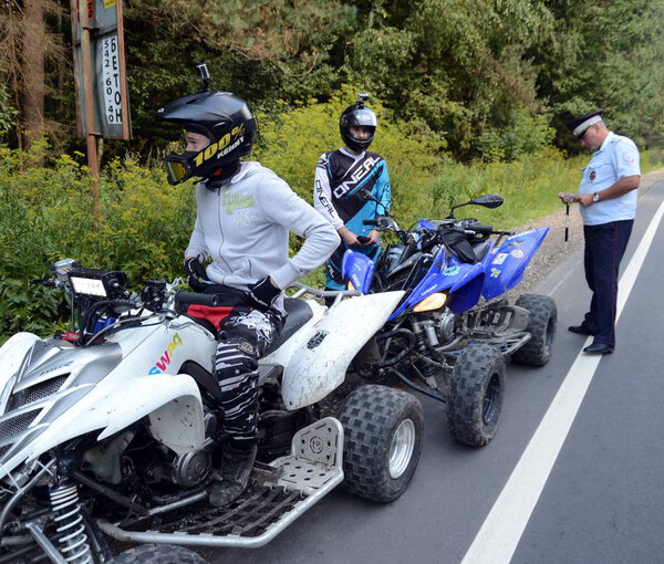  The inspector of the road police patrol stopped the ATV drivers for checking.