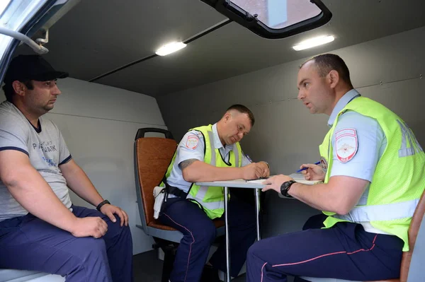 Inspektörer av vägen polisen patrull tjänsten utföra ett protokoll på brott mot trafikregler. — Stockfoto