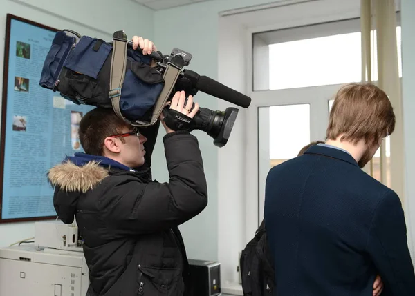 De cameraman houdt een videocamera op zijn hoofd tijdens het opnemen. — Stockfoto