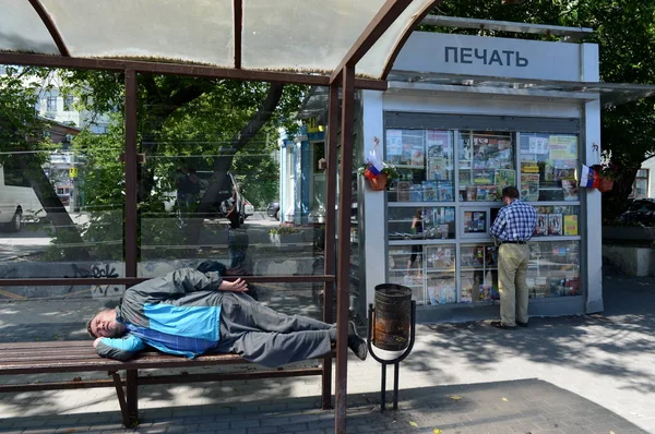 A man is sleeping at a public transport stop in Moscow. — Stock Photo, Image