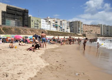 Cadiz, İspanya - 3 Temmuz 2011: İnsanlar Cadiz Atlantic coast plajda sakin ol.