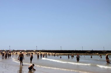 Cadiz, İspanya - 4 Temmuz 2011: La Caleta Atlantik Okyanusu Castillo-Fortalesa de Santa Catalina Kalesi yakınındaki kumsalda.