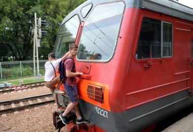 Gençler tren ve tren yolcuları kuyruk araba dış ödeme binmek.