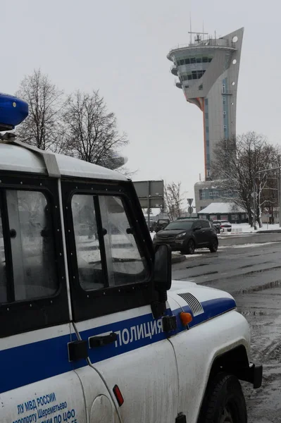 Um carro de polícia no fundo da torre de controle de voo no aeroporto internacional de Sheremetyevo — Fotografia de Stock