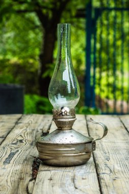 Bahçedeki ahşap bir masa üzerinde eski gaz lambası