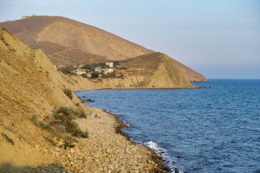 Kırım 'ın Ordzhonikidze köyündeki Cape Karadeniz' de yazın bulutlu, dokulu bir gökyüzü. Ve tepe arazi, manzara