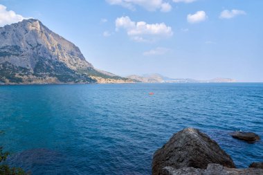 Yeni Dünya köyündeki Green Bay manzarası, kıyı kayalıkları ve ufuktaki dağ sırtı. Falcon Dağı 'nın manzarası. Karadeniz kıyısı, Sudak bölgesi, Kırım Cumhuriyeti