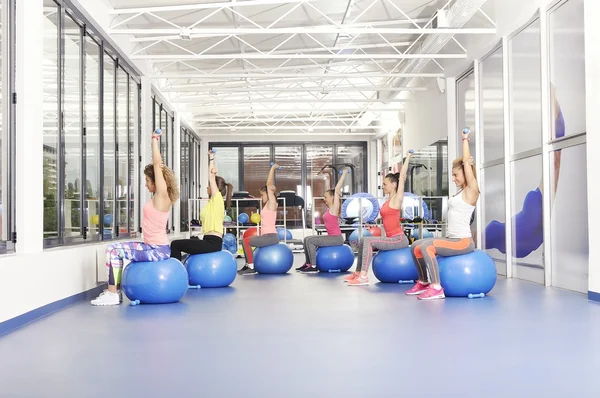 Groep van mooie jonge vrouwen uit te werken op blauwe pilates bal en glimlachen — Stockfoto